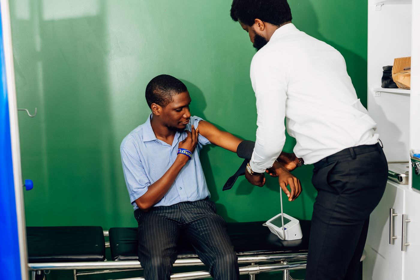 Doctor checking a patient's blood pressure in a Lagos clinic