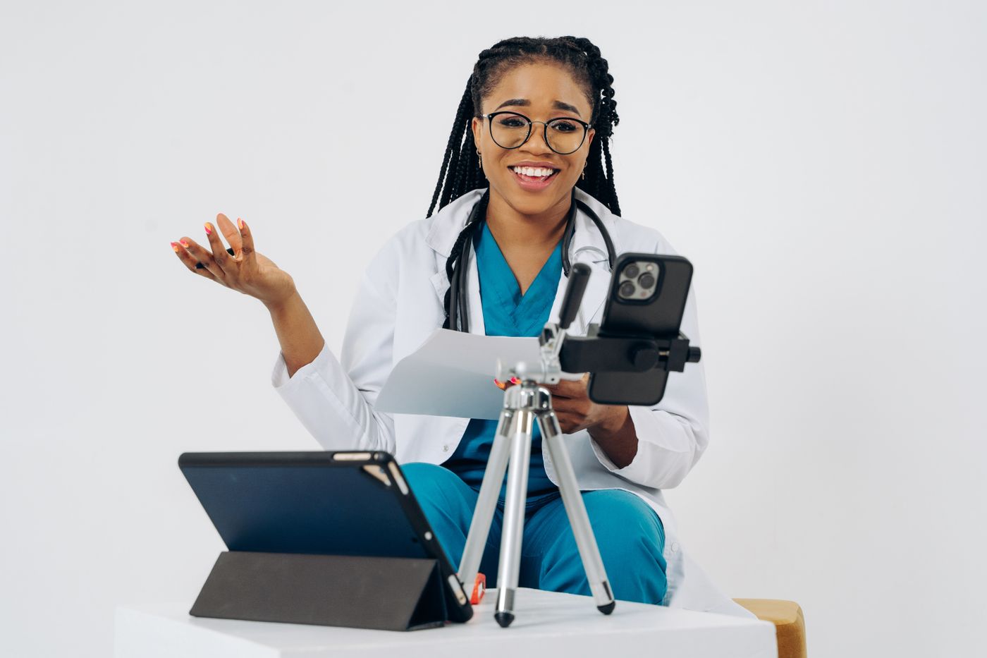 Female doctor using a phone and tablet for a virtual consultation